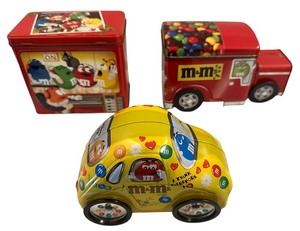 lot 184 image: M&M Tin Bundle M&Ms candy tin shaped like a yellow Volkswagen Beetle,limited edition M&Ms On Air Music Theme Christmas tin from 2005,vintage M&Ms candy tin container truck, often sold as a collectible item