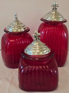 lot 41K image: LR - Set of 3 Red Glass Canisters with Fleur-de-Lis Metal Lids