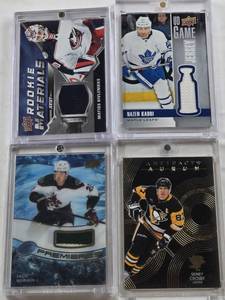lot 119 image: Nazem Kadri 2019-20 Upper Deck UD Game Jersey Patch, Sidney Crosby 2024-25 Upper Deck Artifacts Aurum Patch, Matiss Kivlenieks 2020-21 Upper Deck Rookie Materials Jersey, Jack McBain 2022-23 Upper Deck Ice Premieres Patch