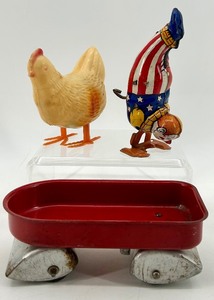 lot 13 image: Vintage J. Chein Clown Wind-Up Tin Toy, Plastic Hen with Eggs, and Red Metal Wagon