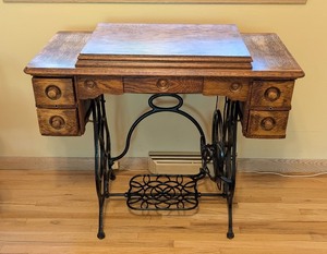 lot 52 image: ML - Vintage Brunswick Treadle Sewing Machine with Ornate Oak Cabinet