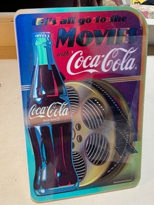 lot 119 image: Coca-Cola Movie Tin Signs, Old Guys Rule Magnet, and Crazy Sista Bottle Opener Set