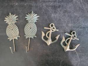 lot 63 image: 2 sets of Heavy Never hung Pineapple and Anchor Coat hangers