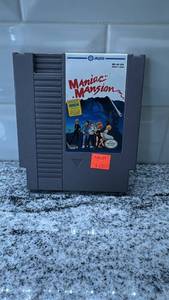 lot 66 image: Maniac Mansion NES Game Cartridge with Protective Case
