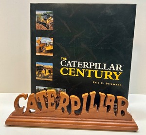 lot 88 image: The Caterpillar Century Book by Eric C. Orlemann with Wooden Caterpillar Desk Sign