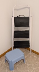lot 85 image: LL - White Folding Step Ladder with 3 Black Steps and Blue Plastic Step Stool
