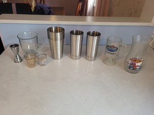 lot 29 image: Collection of Stainless Steel Tumblers, Glass Mugs, and Souvenir Shot Glasses