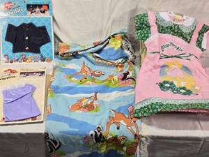 lot 91 image: Pound Puppies Outfits, Cabbage Patch Kids Dress, and Bambi Blanket