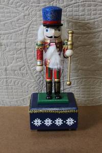 lot 130 image: Holiday Nutcracker Marionette Music Box with Blue Hat and Glitter Details