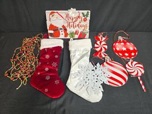 lot 41 image: Holiday Decor Lot with Christmas Stockings, Ornaments, Garland, and Santa Sign