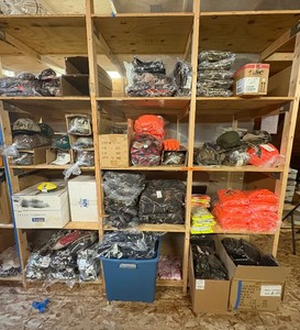 lot 135 image: 3 shelves of camoorange hunting gear. Jackets, sweatshirts, hats, foam footballs