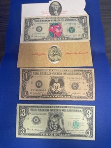 lot 41 image: Three Novelty Dollars Mickey Mouse, 3 Dolar Hilary Bill aand Santa Dollar