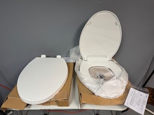 lot 75 image: Two White Oblong Toilet Seats.  Unused. (One missing attachment pieces)