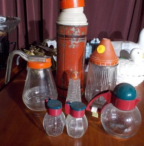 lot 160 image: The image features a collection of vintage kitchenware, including several glass salt and pepper shakers and a vintage thermos bottle.