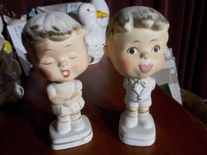 lot 163 image: The image displays a pair of vintage Enesco ceramic kissing bobblehead nodders.