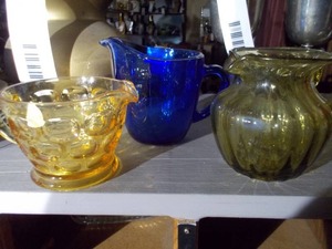 lot 210 image: These are vintage or collectible colored glass creamers and pitchers.