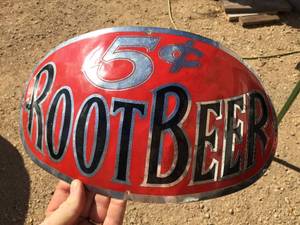 lot 107 image: Nifty 5 Root Beer Shaped BarrelKeg Metal SignBadge
