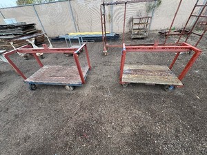 lot 74 image: (2) Industrial flatbed cartsdollies with wood plank deck and caster wheels. Includes central lifting eye