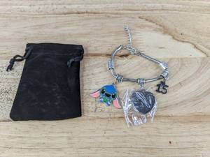 lot 166 image: Disneys Stitch Charm Bracelet with Gift Pouch - Brand New