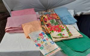 lot 384 image: Lot of Tablecloths and Linens including DesignWare Plastic Tablecover, Various Patterns, and Colors