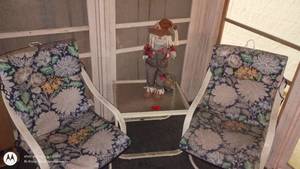 lot 81 image: Patio Set with 2 Floral Cushioned Chairs, Glass-Top Table, and Scarecrow Decor