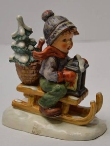 lot 109 image: Goebel Hummel Figurine Boy on Sled with Tree and Lantern