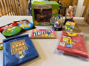 lot 56 image: The Simpsons Collectibles Lot with Buttons, Figures, Book, and Lunch Sacks