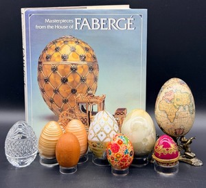 lot 66 image: Decorative Egg Collection Glass, Lattice, Map-Printed Eggs, Cherub Stand & Masterpieces from the House of Faberge Book