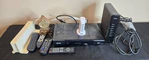 lot 223 image: Collection of Xfinity Modems, Cisco Cable Boxes, USB Charger, Remotes, and Decorative Clock