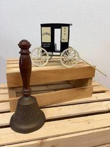 lot 16 image: Antique handheld brass school Bell cast-iron and mailman John Deere wagon