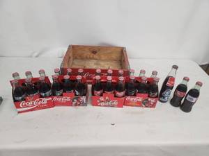 lot 53 image: Collection of Vintage Coca-Cola Bottles with Holiday Labels and Wooden Crate