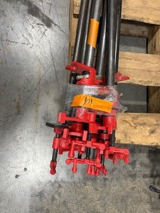 lot 101 image: Black pipe bars, various lengths with red pipe clamps that have swing handles