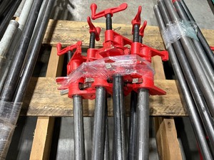 lot 103 image: Black pipe bars with red pipe clamps that have swing handles