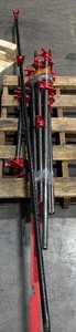 lot 104 image: Black pipe bars with red pipe clamps that have swing handles