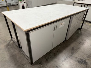 lot 224 image: Steel base wlaminated 4x8 top bottom has one side open, one side retrofitted wdrawers & 2-door cabinet