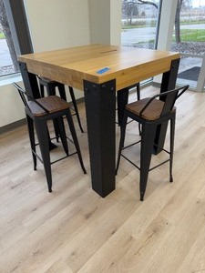 lot 253 image: Industrial Bar-height wood (approx 3-4 thick) table with heavy steel legs. (4) metal bar stools with peg legs