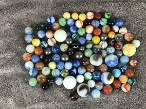 lot 204 image: Lot of Collectible Marbles - one illuminates green when hit with the black light but has a really bad chip in it
