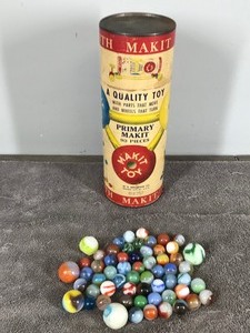 lot 205 image: Lot of Collectible Marbles and Vintage Make It Toy Container - One illuminates green when hit with a black light but has some pretty bad chips