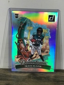 lot 410 image: 2025 Donruss Oversized Downtown Travis Hunter Rookie Card #13 - Card is in Top Loader