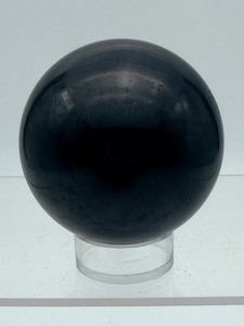 lot 63 image: Shungite Sphere 60 mm  303 gm  10.6 oz. a natural, carbon-rich mineraloid found almost exclusively in the Republie of Karelia, Russia. Known for water purification & EMF protection.