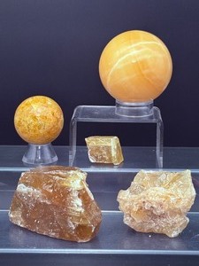 lot 192 image: Honey Calcite Polished and Rough Lot of 5 sphere 63mm  400 gm.  14 oz., sphere 42 mm  126 gm.  4.4 oz., 2 rough chunks & 1 sm piece 430 gm.  15.1 oz.