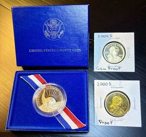 lot 42 image: Toned Proof 1986 Liberty Half Dollar in Display Box  (2) Proof Sac Dollar Coins