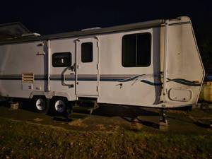 lot 4 image: Fleetwood Prowler Travel Trailer Camper with Bedroom and Living Area