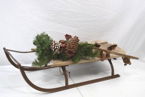 lot 33 image: Vintage Wooden Sled with Pinecone Holiday Decor And Antique Ice Skates, 32 x 13 in