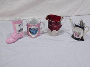 lot 34 image: Souvenir Ceramic & Glass Collectibles pink ceramic boot with an image of the Lincoln Monument, pink mug with a general view of Niagara Falls, red glass pitcher Souvenir of Niagara Falls, N.Y., teapot with floral design Souvenir of Fort William, Ont