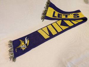 lot 25 image: Minnesota Vikings Knit Scarf Purple and Yellow - Bold VIKINGS on one side, and LETS GO VIKINGS on the reverse side