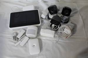 lot 102 image: Home Security System Components with Cameras, Sensors, and Control Panel