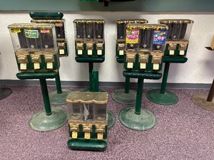 lot 85 image: 7 Pc Lor 7 Metal and plastic Candy Machines with Plastic Stands, Varried Condition