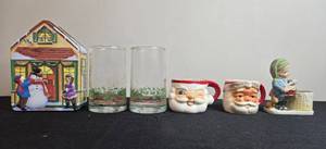 lot 86 image: Vintage Christmas Holiday Decor Collection Including Mugs, Figurines, Glasses, and Tin House