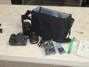 lot 400 image: Canon EOS R100 Camera with Camera Shoulder Bag, Canon 55-210 Lens, Canon 18-45 Lens, Memory Card, Battery and Charger